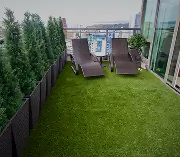 Rooftop patio with lounge chairs and green turf flooring
